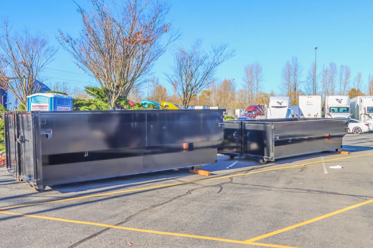 Professional dumpster rental service with roll-off container on residential driveway in Wellsville